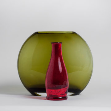 Still life of red bottle and green vase