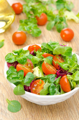 bowl of fresh salad and cherry tomatoes in white bowl, vertical
