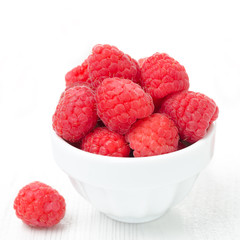 bowl with fresh raspberries on a white background close-up