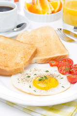 Fried eggs, fresh tomatoes and crunchy toast for breakfast
