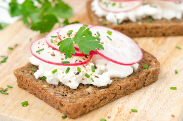 grain bread with soft cheese, radish and chives, horizontal