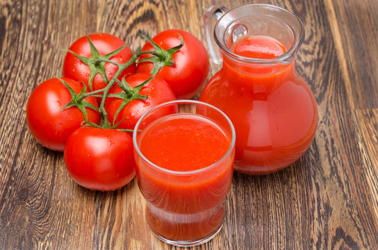 glass and jug of tomato juice, fresh tomatoes on wooden table