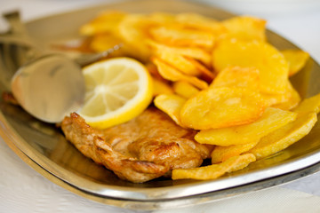 fried meat with potato and lemon