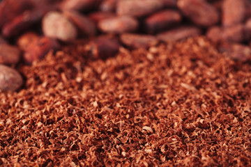 cocoa beans and grated chocolate background, shallow dof