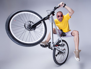 crazy boy on a dirt jump bike on grey background - wide studio s