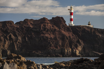 Fototapeta na wymiar Cliff rocky coast and lighthouse at sunset