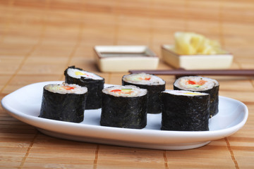 dish with fresh sushi rolls on bamboo napkin background