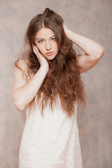 Fototapeta premium Sensual fashion woman with long hair. Wearing beige dress. Marbl