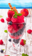 Strawberry ice cream in cup on wood