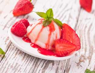 Strawberry ice cream in cup on wood