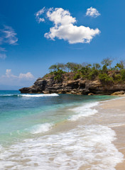 View from a sandy beach on rocks at ocean. Indonesia, Bali