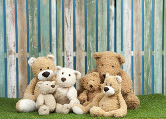 group of teddy bears seated on grass