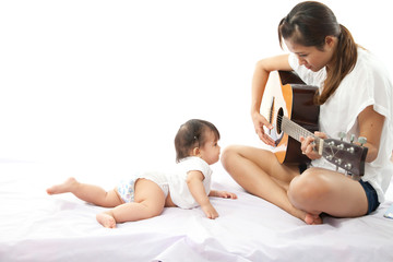 Mother is playing a guitar for her baby