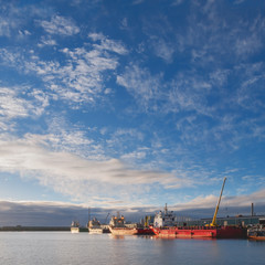 Fototapeta premium Oil platform supply vessels in a port during sunrise