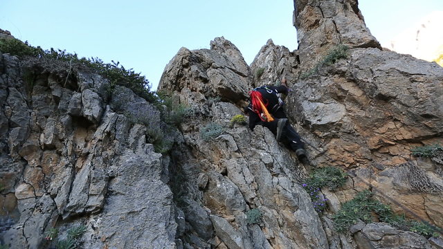 climber climbing the top of the rock