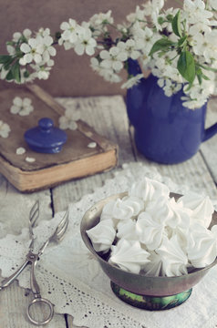 Still life in vintage style with meringue kisses and cherry flow