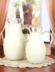 Pitchers of milk on table in room