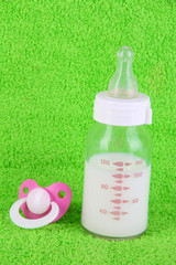 Bottle for milk and nipple on towel background