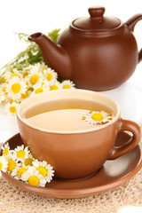 Cup of herbal tea with camomiles close up