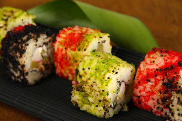 Tasty Maki sushi - Roll on mat on brown background