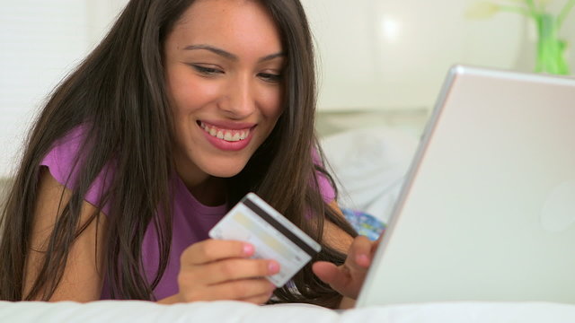 Mexican woman making online purchase using laptop computer in be