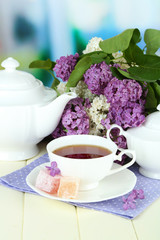 Composition with beautiful lilac flowers, tea service