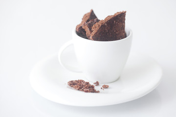 white cup with saucer and chocolate