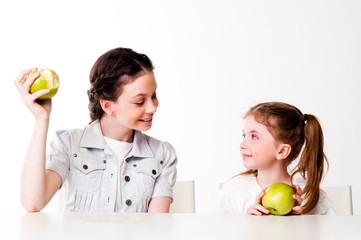 two beautiful girls with green apples