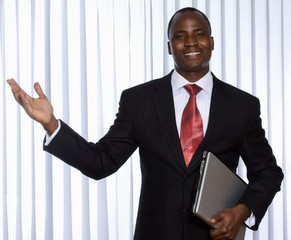 african american showing something, holding a laptop