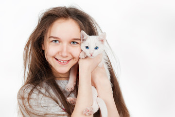 Portrait of a teenage girl with cat, on a gray background