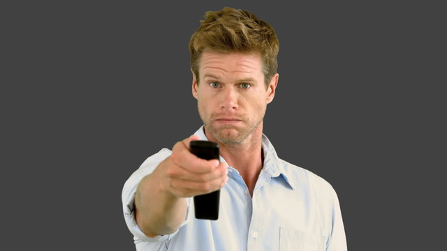 Man using remote on grey screen