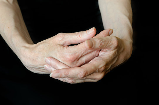 Senior woman's hands on black background