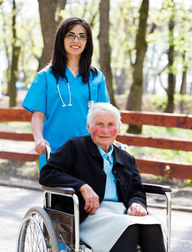 Walking With Senior Patient In Wheelchair