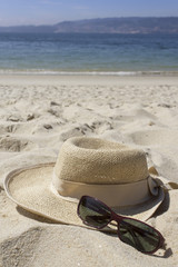 Straw hat and sunglasses on the beach