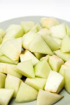 Melon sliced in small pieces served on a plate,