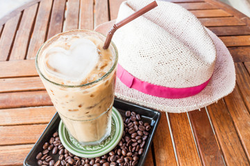 Cold glass of iced milk coffee on wood table