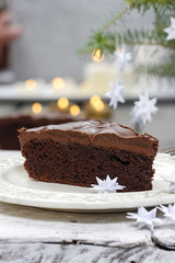Piece of chocolate cake in white christmas table setting. Very s