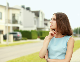 Fototapeta premium Young woman standing near house