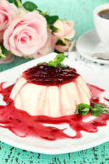 Panna Cotta with raspberry sauce, on color wooden background