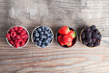 A four bowls overflowing with summer berries