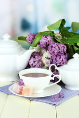 Composition with beautiful lilac flowers, tea service