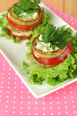 Tasty roasted marrow and tomato slices with salad leaves,