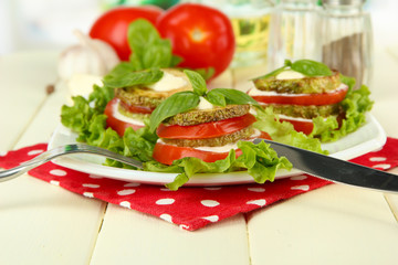 Tasty roasted marrow and tomato slices with salad leaves,