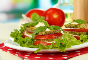 Tasty roasted marrow and tomato slices with salad leaves,