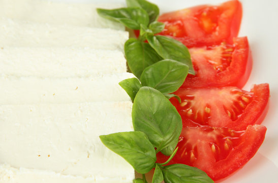 Sheep milk cheese, with basil and tomato, close-up