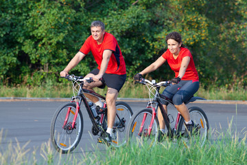 Fototapeta na wymiar mature couple on bicycle