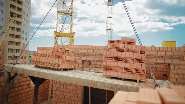 Crane carries bricks at a construction site