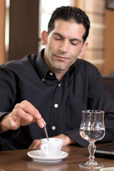 Mann beim umrühren eines Espresso