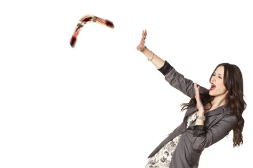 woman defending herself with her hands from the boomerang - obrazy, fototapety, plakaty
