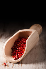 red peppercorns in wooden scoop